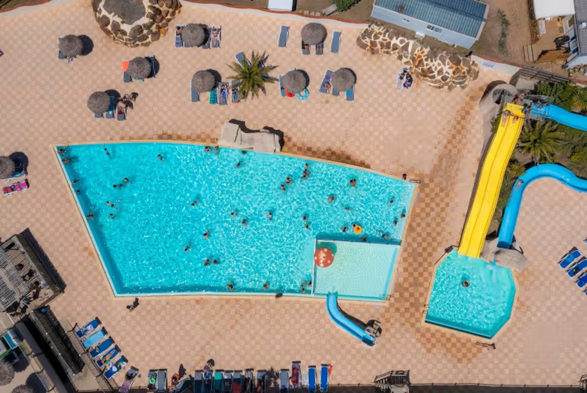 Aerial shot of Camping La Dune des Sables swimming pool – spacious outdoor pool with water slides and sun loungers in the Vendée.