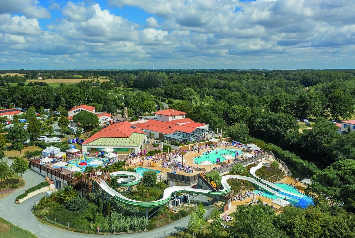 Aerial view of Camping Le Pin Parasol in the Vendée – family-friendly campsite with two water parks, spacious pitches, and lakeside activities.